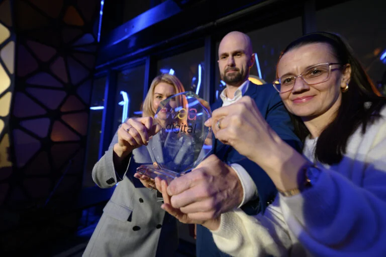 Zespół Vercly prezentuje nagrodę w nowoczesnym biurze z niebieskim oświetleniem
